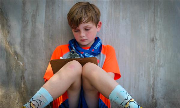 student writes on clipboard